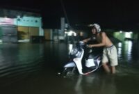 FOTO: Salah seorang warga Kota Sampit yang berjalan melalui banjir di Jalan DI Panjaitan, Kabupaten Kotim. (FOTO: BUDDI). 