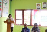 FOTO: Plt. Kepala BIdang Perlindungan Perempuan dan Kualitas Keluarga Mariana saat membacakan sambutan pada acara sosialisasi pergub di Kantor Balai Desa Pamait Kabupaten Barito Selatan