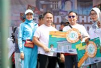 MENYERAHKAN : Gubernur Provinsi Kalteng H. Sugianto Sabran saat menyerahkan secara simbolis hadiah Jalan Sehat Kalteng Berkah kepada masyarakat. (IST)