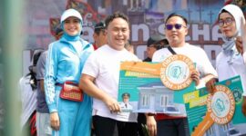 MENYERAHKAN : Gubernur Provinsi Kalteng H. Sugianto Sabran saat menyerahkan secara simbolis hadiah Jalan Sehat Kalteng Berkah kepada masyarakat. (IST)