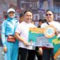 MENYERAHKAN : Gubernur Provinsi Kalteng H. Sugianto Sabran saat menyerahkan secara simbolis hadiah Jalan Sehat Kalteng Berkah kepada masyarakat. (IST)