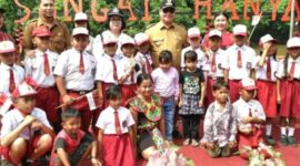 Bupati Kotim Halikinnor bercengkerama dengan murid SD yang menyambutnya saat tiba di Desa Sungai Hanya Kecamatan Antang Kalang untuk meresmikan listrik PLN yang masuk ke desa. (IST)