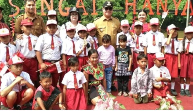 Bupati Kotim Halikinnor bercengkerama dengan murid SD yang menyambutnya saat tiba di Desa Sungai Hanya Kecamatan Antang Kalang untuk meresmikan listrik PLN yang masuk ke desa. (IST)