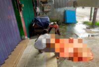 Petugas saat mengevaluasi jasad mayat pria tak beridentitas yang di temukan di depan ruko Jalan Pangeran Antasari.(IST)