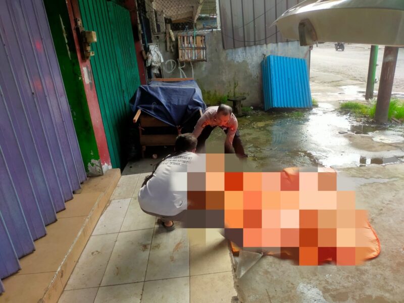Petugas saat mengevaluasi jasad mayat pria tak beridentitas yang di temukan di depan ruko Jalan Pangeran Antasari.(IST)