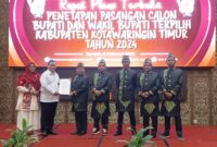 PENYERAHAN: Ketua KPU Kotim Muhammad Rifqi saat menyerahkan salinan keputusan calon bupati dan wakil Bupati Kotim terpilih kepada H.Halikinnor usai Rapat Pleno, Kamis (6/2).(IST)