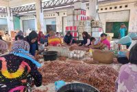 PENGUPASAN : Sejumlah warga saat mengupas kulit dan kepala udang di PP Kuala Pembuang, belum lama ini.(IST)