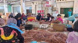 PENGUPASAN : Sejumlah warga saat mengupas kulit dan kepala udang di PP Kuala Pembuang, belum lama ini.(IST)