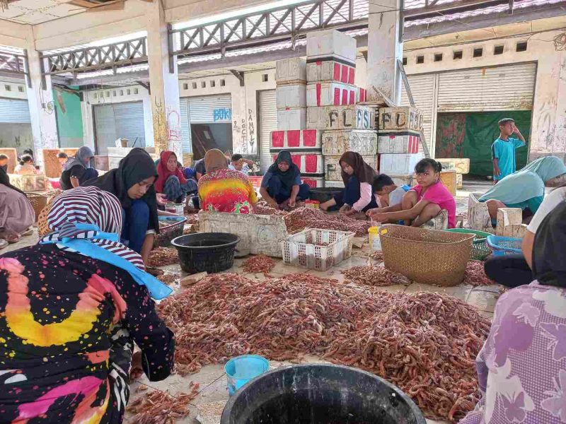 PENGUPASAN : Sejumlah warga saat mengupas kulit dan kepala udang di PP Kuala Pembuang, belum lama ini.(IST)
