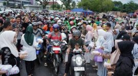 BERBAGI : Ketua TP-PKK Provinsi Kalteng, Aisyah Thisia Agustiar Sabran, saat membagikan 1.000 takjil kepada masyarakat di Bundaran Besar Palangka Raya, Minggu (9/3).(IST)