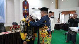 MENGALUNGKAN : Plt Kepala Biro Kesra Setda Kalteng Ahmad Pahruka saat mengalungkan tanda kepesertaan umrah kepada salah satu jamaah saat kegiatan manasik haji di Aula Asrama Haji Al Mabrur, Kamis (6/3). (IST)