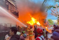 MEMADAMKAN : Para petugas pemadam kebakaran sedang berjibaku memadamkan api yang melalap gudang rongsokan, pada Sabtu (5/4).(IST)