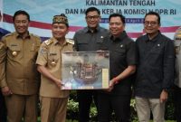 CENDRAMATA : Gubernur Provinsi Kalteng H. Agustiar Sabran saat memberikan cinderamata kepada Ketua Komisi V DPR RI, Lasarus, yang juga Ketua Tim Kunjungan Kerja Reses yang dilaksanakan di Aula Eka Hapakat, LT. III Kantor Gubernur Kalteng, Senin (14/4).(IST)