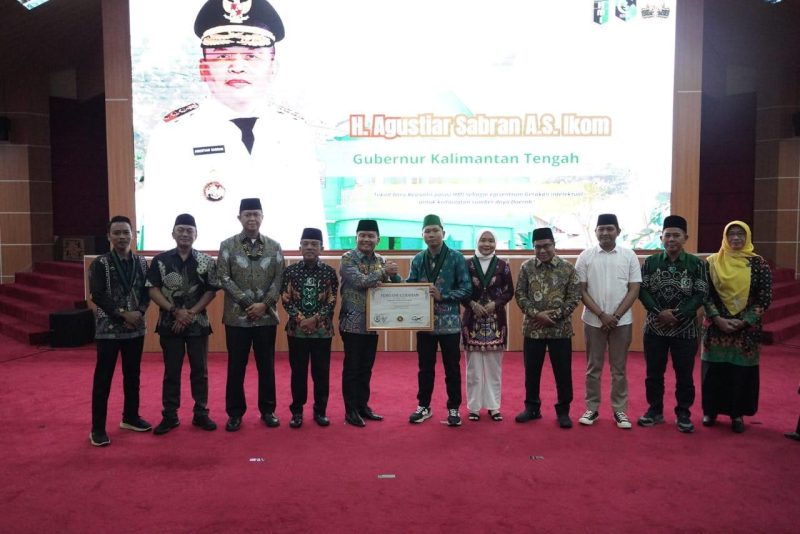 PENGANUGERAHAN : Gubernur Kalimantan Tengah, H. Agustiar Sabran saat memberikan Piagam Penganugerahan kepada Ketua Umum HMI Cabang Palangka Raya Permutih Imam Basar yang didampingi pengurus lainnya, Jumat (30/5).(IST)