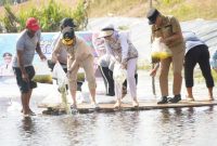 RESTOCKING : Gubernur Kalteng H. Agustiar Sabran bersama Ketua TP-PKK Provinsi Kalteng Aisyah Thisia Agustiar Sabran saat turut serta dalam kegiatan restocking benih ikan di Embung BWS Kalimantan II yang berlokasi di Danau Asam Kecamatan Kotawaringin Lama, pada Minggu (8/6).(IST)