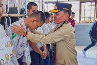 MENGALUNGKAN : Gubernur Kalimantan Tengah H. Agustiar Sabran secara simbolis mengalungkan tanda peserta MPLS kepada perwakilan siswa baru SMA Negeri 1 Muara Teweh, Kabupaten Barito Utara, Selasa (8/7/2025).(IST)