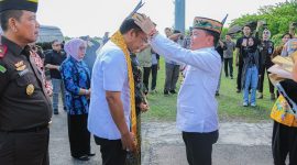 PASANGKAN : Gubernur Kalteng H. Agustiar Sabran saat memasangkan lawung kepada Kepala Kejaksaan Tinggi Kalimantan Tengah yang baru Agus Sahat Sampe Tua Lumban Gaol, dalam prosesi penyambutan adat di Bandara Tjilik Riwut Palangka Raya, Jumat (18/7/2025).(IST)