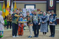 SERAHKAN : Gubernur Kalteng, H.Agustiar Sabran, saat menyerahkan cinderamata kepada mantan Kajati Kalteng, Undang Mugopal saat kenal pamit yang digelar di Aula Jayang Tingang, Kantor Gubernur Kalteng, Jumat (18/7/2025).(IST)