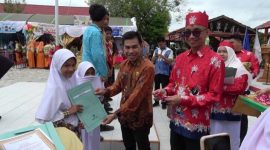 PENGHARGAAN : Kepala Seksi Peserta Didik dan Prasarana Disdik Kotim, M Ikram Muhajir, didampingi Kepala SMPN 4 Sampit, Anjar Subiantoro saat memberikan penghargaan kepada salah satu siswa, Selasa, (24/6/2025).(IST)