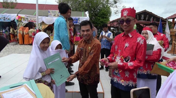 PENGHARGAAN : Kepala Seksi Peserta Didik dan Prasarana Disdik Kotim, M Ikram Muhajir, didampingi Kepala SMPN 4 Sampit, Anjar Subiantoro saat memberikan penghargaan kepada salah satu siswa, Selasa, (24/6/2025).(IST)