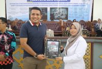 CENDRAMATA : Ketua Bidang Komunikasi dan Informasi HIPMI Kabupaten Kotim Muhammad Chalid saat menerima cenderamata langsung dari sutradara film Ternyata Aku Korban, Novita Sari M.H, pada acara Nonton Bareng yang digelar di Gedung Serbaguna Sampit, Kamis (7/8/2025). (IST)