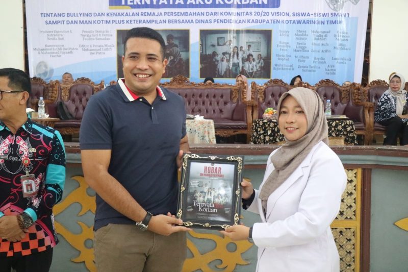 CENDRAMATA : Ketua Bidang Komunikasi dan Informasi HIPMI Kabupaten Kotim Muhammad Chalid saat menerima cenderamata langsung dari sutradara film Ternyata Aku Korban, Novita Sari M.H, pada acara Nonton Bareng yang digelar di Gedung Serbaguna Sampit, Kamis (7/8/2025). (IST)