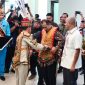 MEMASANGKAN : Gubernur Kalteng H Agustiar Sabran memasangkan kelengkapan adat dayak kepada Menteri Koperasi dan UKM RI, Ferry Joko Juliantono, saat kunjungan kerja ke Kalimantan Tengah, Kamis (25/9/2025).(IST)