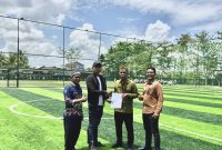 MENYERAHKAN :  Direktur Utama PT Permata Energi Borneo, Noor Febriyanto, didampingi  Pihak Penerbit saat menyerahkan lapangan mini soccer kepada kepala sekolah SMAN 2 Sampit Drs. Kodarahim belum lama ini.(IST)