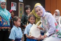 BERIKAN : Ketua TP Posyandu Aisyah Thisia Agustiar Sabran saat memberikan bingkisan kepada anak-anak saat Sosialisasi dan Pembinaan 6 Standar Pelayanan Minimal (SPM) di Aula Bappedalitbang Kabupaten Katingan, Selasa (30/9/2025).(IST)