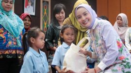 BERIKAN : Ketua TP Posyandu Aisyah Thisia Agustiar Sabran saat memberikan bingkisan kepada anak-anak saat Sosialisasi dan Pembinaan 6 Standar Pelayanan Minimal (SPM) di Aula Bappedalitbang Kabupaten Katingan, Selasa (30/9/2025).(IST)