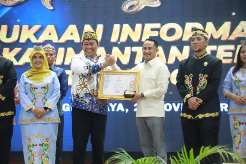 SERAHKAN : Wagub Kalteng Edy Pratowo saat memberikan penghargaan kepada wali Kota Palangka Raya dengan predikat Informatif pada Anugerah Keterbukaan Informasi Publik Provinsi Kalimantan Tengah Tahun 2025 di Aula Jayang Tingang, Kantor Gubernur Kalteng, Selasa (25/11/2025).(IST)