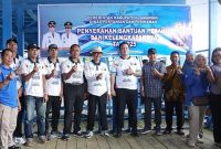 MENYERAHKAN : Bupati Lamandau Rizky Aditya Putra bersama Wakil Bupati Abdul Hamid saat menyerahkan 54 unit perahu beserta perlengkapannya kepada kelompok nelayan di Dermaga Batu Bisa, Minggu (7/12/2025).(IST)