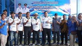 MENYERAHKAN : Bupati Lamandau Rizky Aditya Putra bersama Wakil Bupati Abdul Hamid saat menyerahkan 54 unit perahu beserta perlengkapannya kepada kelompok nelayan di Dermaga Batu Bisa, Minggu (7/12/2025).(IST)