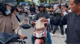 BERBAGI : Ketua PWI Kalteng, M. Zainal,saat membagikan takjil kepada masyarakat yang melintas di depan Kantor PWI Kalteng, Jalan RTA Milono, Palangka Raya, Sabtu (7/3/2026) sore.