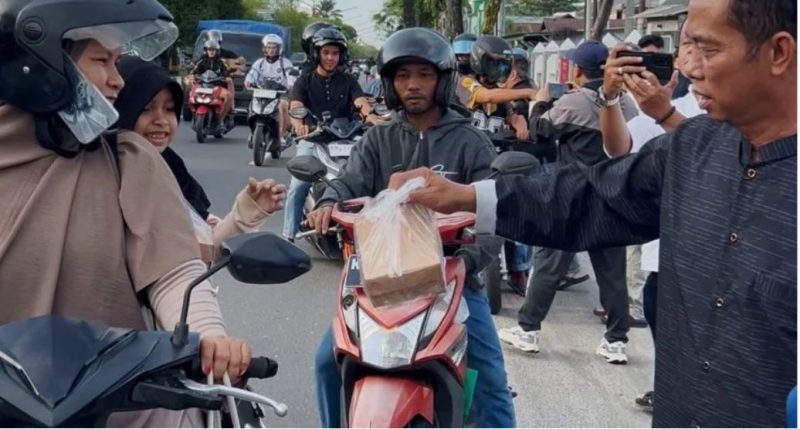 BERBAGI : Ketua PWI Kalteng, M. Zainal,saat membagikan takjil kepada masyarakat yang melintas di depan Kantor PWI Kalteng, Jalan RTA Milono, Palangka Raya, Sabtu (7/3/2026) sore.