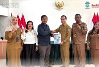 SERAHKAN : Kepala Dinas Komunikasi dan Informatika, Statistik dan Persandian Kabupaten Lamandau Herwinson menyerahkan laporan secara langsung kepada Wakil Ketua Komisi Informasi Provinsi Kalteng, Selasa (17/3/2026).(diskominfostandilamandau)