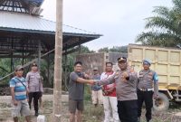 SERAHKAN: Kapolsubsektor Telaga Antang Ipda Yoyo Prasetyo, S.Sos saat menyerahkan bantuan batako dan semen untuk pembangunan Masjid Al-Jami di Desa Tumbang Boloi, Kecamatan Telaga Antang, Kabupaten Kotawaringin Timur, Jumat (14/8).