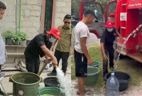 DISTRIBUSIKAN : Bupati Lamandau Rizky Aditya Putra turun langsung memantau proses distribusi air bersih kepada warga, belum lama ini.